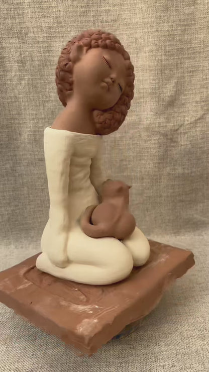 Short rotating video of a handcrafted clay woman and cat figurine, showing the sculpture from all angles and revealing handmade details and natural ceramic texture